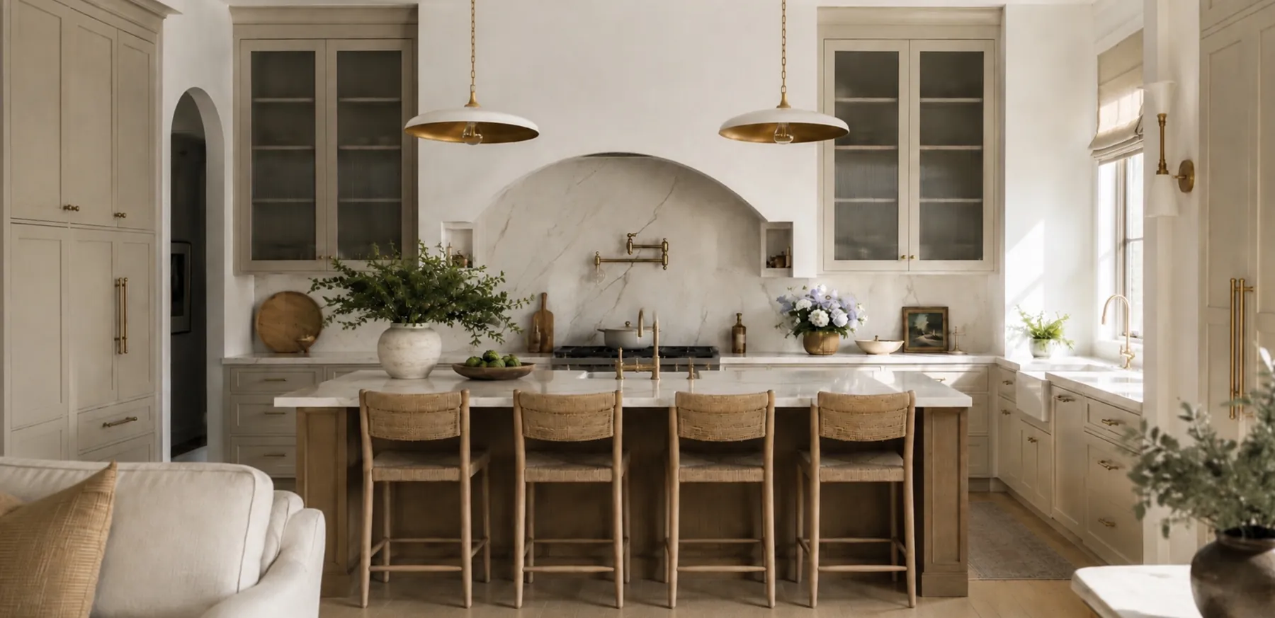 A kitchen with a plaster hood, a long island with rush seat stools and glass-front uppers.